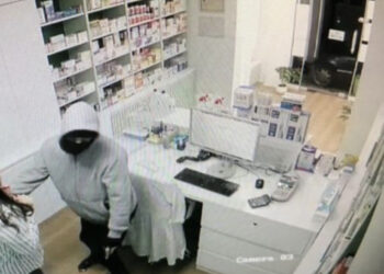 Del fotoja nga grabitja në TIRANË, i veshur me kostum gri dhe maskë, merr paratë e xhiros