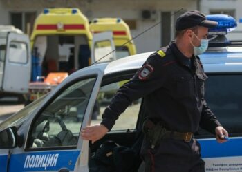 Vriten tre persona afër një stacioni hekurudhor në Rusi